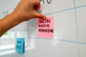 une main écrit sur un post-it