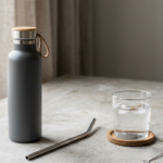 Une mise en scène moderne montre une paille en inox avec une gourde et une brosse de nettoyage. L’ensemble illustre un usage réutilisable, pratique et plus premium au quotidien.