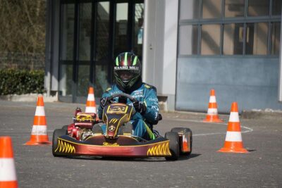 Un conducteur en karting porte un casque vert et bleu
