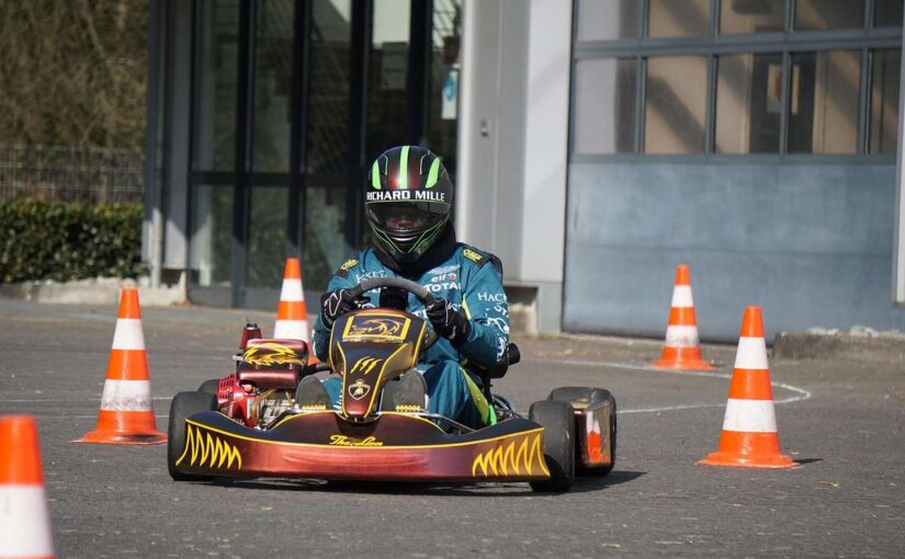 Un conducteur en karting porte un casque vert et bleu