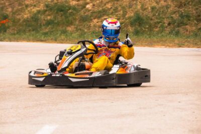 Un pilote casqué au volant d'un kart sur un circuit