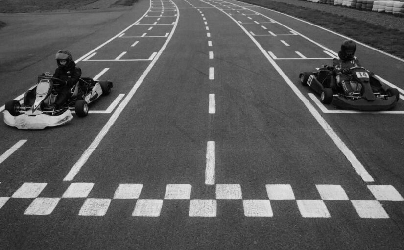 Deux kartingistes pilotent leurs kart à la ligne d'arrivée