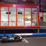 Un kart sur piste intérieure devant une salle vitrée
