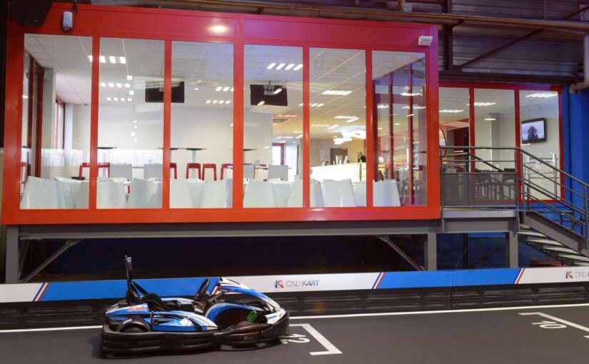 Un kart sur piste intérieure devant une salle vitrée