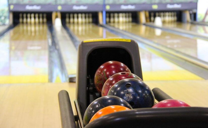 Flacon de boules colorées dans le porte-balles d'une piste de bowling