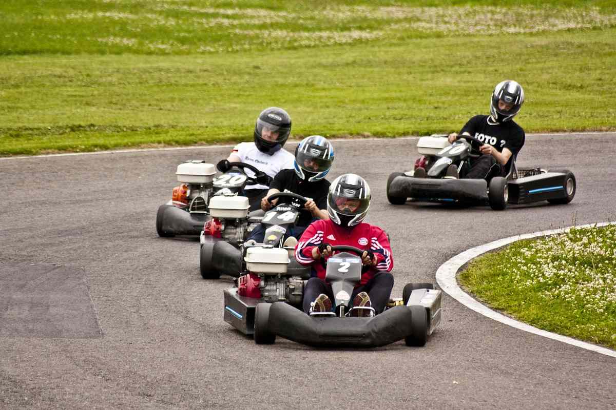 Quatre conducteurs en karting tournent sur un circuit asphalté Quatre conducteurs en karting tournent sur un circuit asphalté