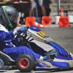 Un pilote de karting en tenue bleue conduit son véhicule sur circuit