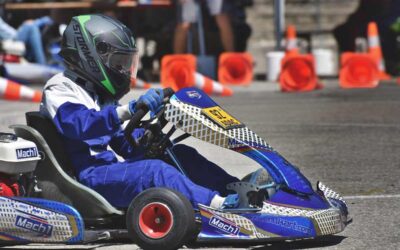 Un pilote de karting en tenue bleue conduit son véhicule sur circuit