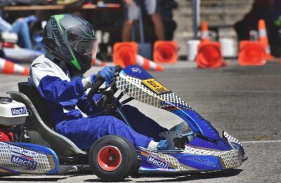 Un pilote de karting en tenue bleue conduit son véhicule sur circuit