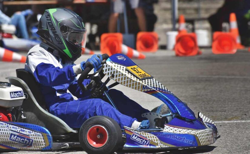 Un pilote de karting en tenue bleue conduit son véhicule sur circuit